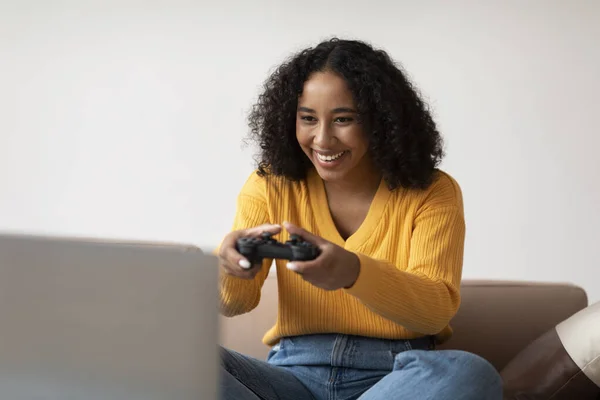 自宅でラップトップPc上でコンピュータゲームをプレイゲームジョイスティックを持つクールな若い黒人女性 ミレニアル世代アフリカ系アメリカ人女性ゲーマーがスポーツ競技会にオンラインで参加 — ストック写真