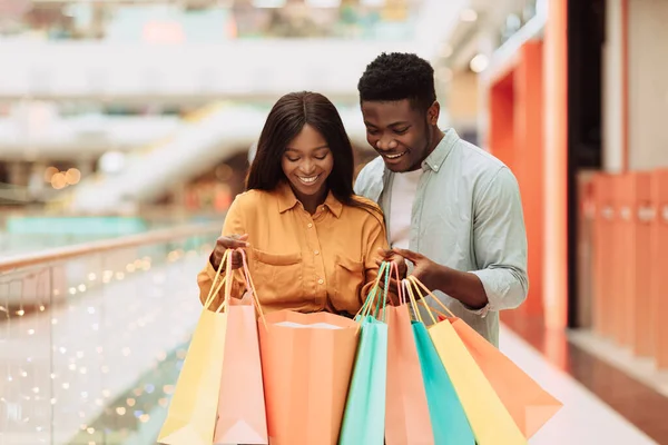 Emocionada Pareja Negra Sosteniendo Mirando Dentro Abierto Coloridas Bolsas Compras —  Fotos de Stock