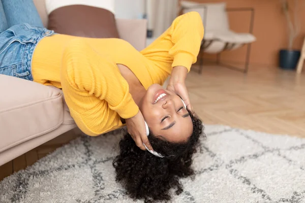 Счастливая Молодая Черная Женщина Наушниках Лежит Диване Закрытыми Глазами Дома — стоковое фото