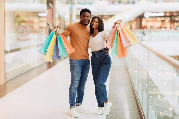 Hermosa pareja negra sosteniendo bolsas de compras mirando posando en la cámara —  Fotos de Stock