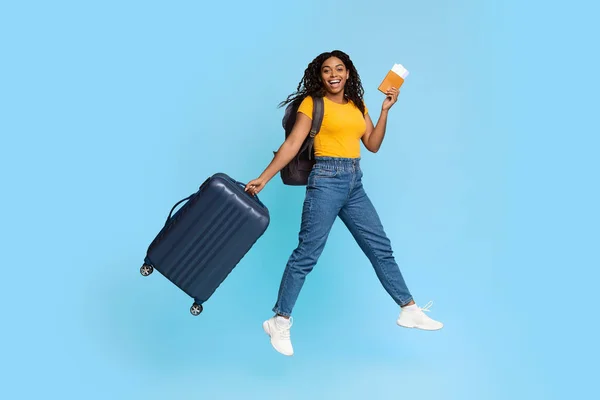 Emotionale Afroamerikanerin mit Koffer und Flugtickets — Stockfoto