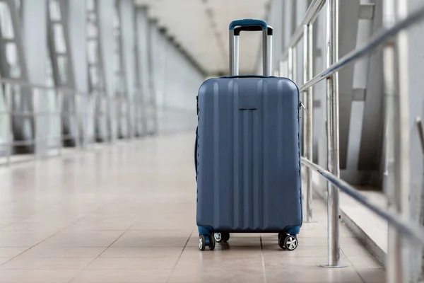 Primo piano colpo di elegante valigia bagaglio a mano in piedi nella sala vuota dell'aeroporto — Foto Stock