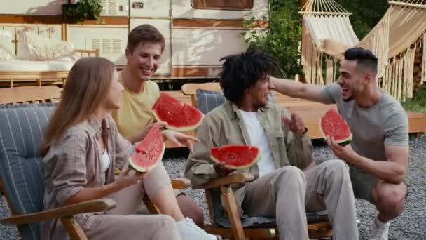 Grupo de amigos multiétnicos felices comiendo sandía en la fiesta al aire libre en el camping — Vídeo de stock