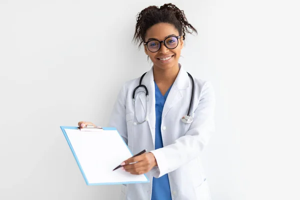 Portret czarnego lekarza patrzącego na kamerę pokazującą schowek — Zdjęcie stockowe