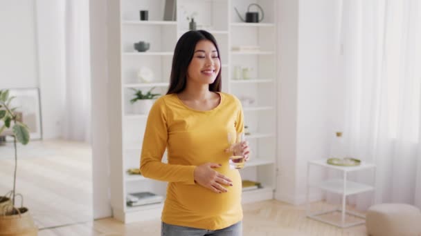 Hydratatie van het lichaam. jong zwanger aziatische vrouw drinken water uit glas thuis — Stockvideo