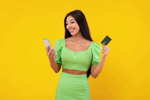 Spännande ung kvinna med kreditkort och mobiltelefon — Stockfoto