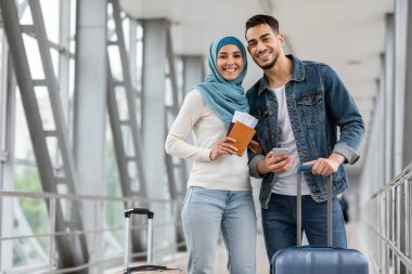 Havalimanında Bavul ve Smartphone 'la duran mutlu İslami Çiftin Portresi
