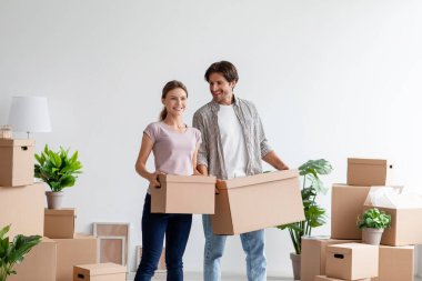 Bin yıllık Avrupalı kadın ve erkeğin gelişigüzel karton kutular taşımasına, eşyalarının paketlenmesine ve taşınmasının keyfini çıkarmasına sevindim.