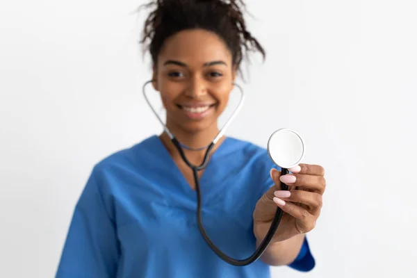 Portrait of black doctor smiling and showing stethoscope — Stock Photo, Image