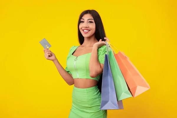 Glad dam med kreditkort som bär shoppingväskor — Stockfoto