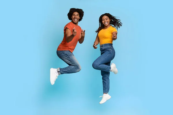 Happy african american lovers celebrating success on blue — Stock Photo, Image