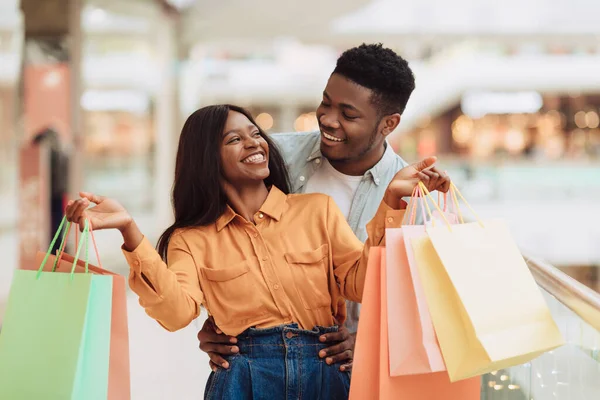 Portrait of excited black couple walking with shopping bags — Stock Photo, Image
