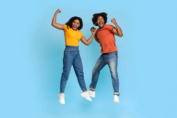 Funny african american millennials showing muscles on blue — Stock Photo, Image