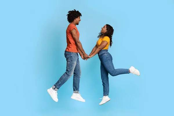 Liefdevolle zwarte man en vrouw hand in hand op blauw — Stockfoto