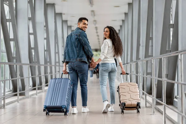 Romantyczna młoda para z Bliskiego Wschodu spacerująca razem w terminalu na lotnisku — Zdjęcie stockowe