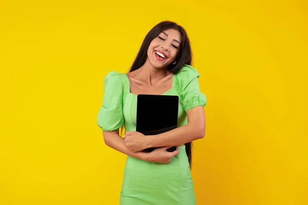 Любитель технологий. Возбужденная женщина обнимает цифровой планшет — стоковое фото