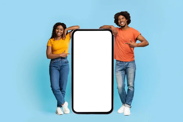 Snygga svarta Millennials poserar med stor mobiltelefon, mockup — Stockfoto