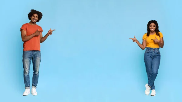 Beau noir homme et femme montrant l'espace de copie sur bleu — Photo