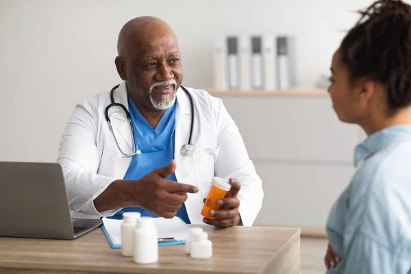 Ervaren zwarte arts tonen pillen aan vrouwelijke patiënt — Stockfoto