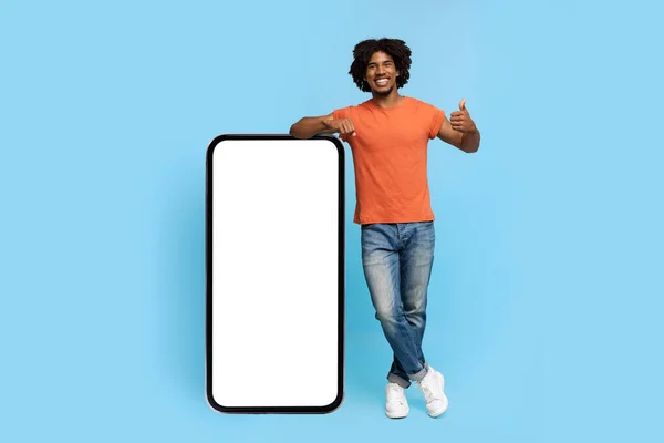 Positivo Africano americano cara posando com smartphone com tela em branco — Fotografia de Stock