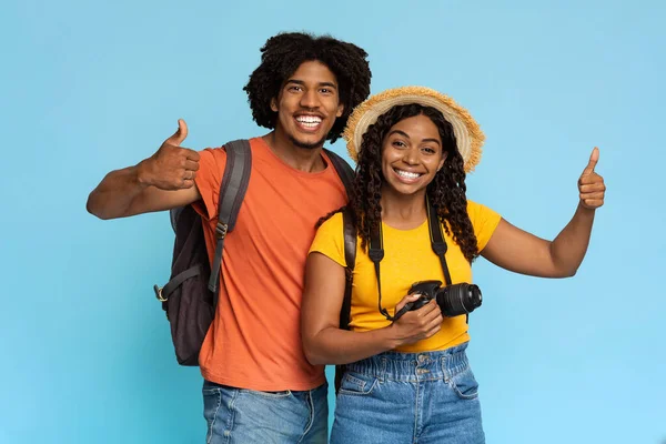 Ευτυχισμένο ζευγάρι Αφροαμερικανών που ταξιδεύουν μαζί, δείχνοντας τους αντίχειρες — Φωτογραφία Αρχείου
