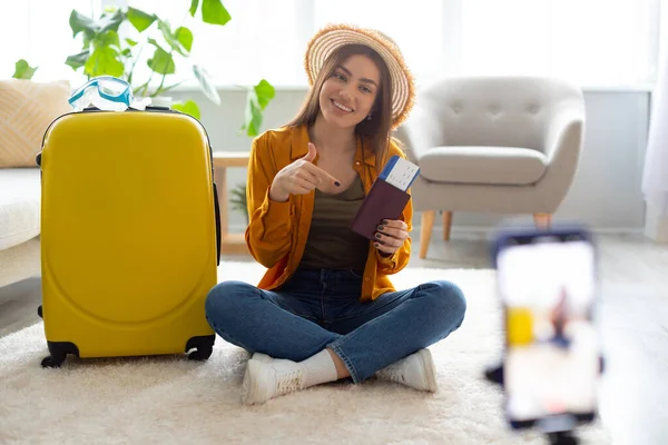 Travel blogger riprese video sul cellulare, mostrando passaporto e biglietto, contenuti in diretta streaming per il suo vlog a casa — Foto Stock