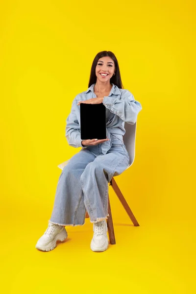 Mujer joven feliz mostrando pantalla de tableta vacía negro —  Fotos de Stock