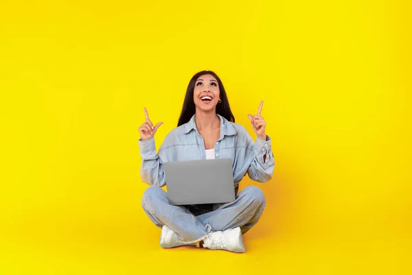 Szczęśliwa pani za pomocą laptopa wskazując w studio — Zdjęcie stockowe