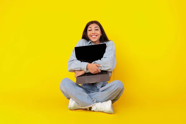 Εραστής τεχνολογίας. Ενθουσιασμένη γυναίκα αγκαλιάζει φορητό υπολογιστή στο στούντιο — Φωτογραφία Αρχείου