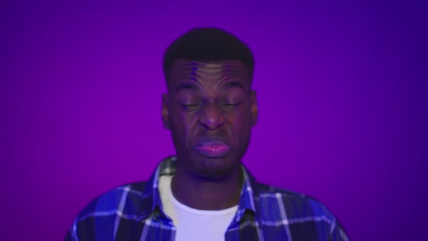 Undorodó afrikai férfi ráncolás érzés rossz szag felett lila háttér — Stock videók