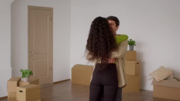 Šťastný manžel drží manželku spinning mezi stěhování boxy doma — Stock video