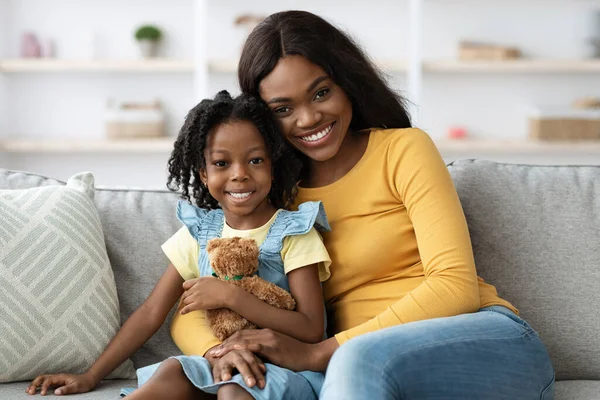 Porträt von hübsch jung schwarz mutter und female child posieren bei zuhause — Stockfoto