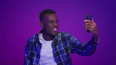 Siyah adam Smartphone Poz Vererek Mor Arkaplanda Selfie Çekiyor