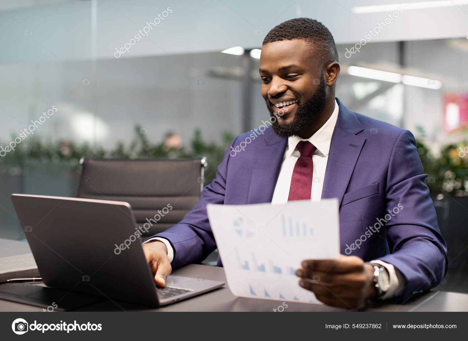 Heureux homme d'affaires noir vérifier les rapports dans le bureau moderne  — Photo de stock par ©Milkos - 549237862, image size:1600x1167