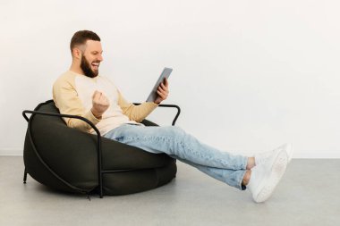 Dijital Tablet Kullanan Adam Sandalyede Oturan Yumrukları Sallıyor