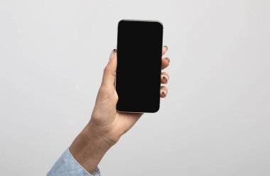 İş kadını eli boş siyah ekranlı akıllı telefonu gösterir, uygulama veya web sitesi tasarımı için alan gösterir