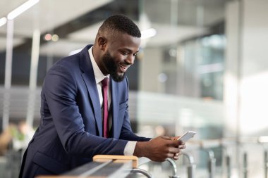 Afrika kökenli Amerikalı CEO akıllı telefondan iş telefonu uygulaması kullanıyor.
