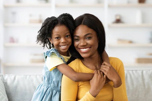 Młoda piękna czarna kobieta i jej słodkie nastolatka córka pozowanie w domu — Zdjęcie stockowe