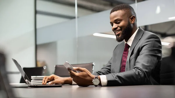 Beau homme d'affaires noir utilisant des gadgets modernes dans le processus d'affaires, panorama — Photo