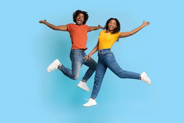 Radosny afrykański Amerykanin mężczyzna i kobieta skaczący na niebiesko — Zdjęcie stockowe