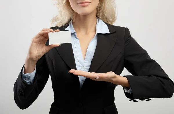 Nierozpoznawalna bizneswoman pokazująca pustą wizytówkę z makietą do projektowania, stojąca nad jasnym tłem, uprawa — Zdjęcie stockowe
