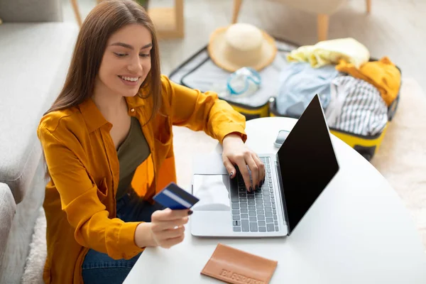 Genç bayan internet seyahat sitesi için kredi kartı ve dizüstü bilgisayar kullanıyor. Yurt dışına seyahat rezervasyonu yapıyor. — Stok fotoğraf