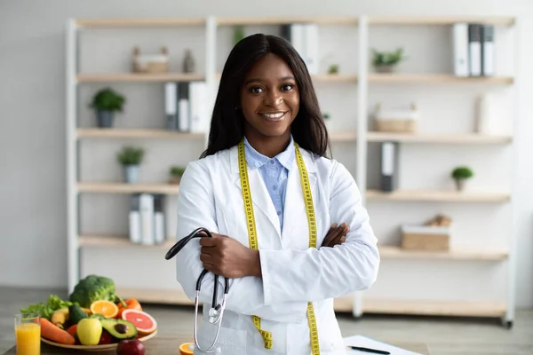 줄자와 청진기가 있는 우호적 인 아프리카 계 미국인 영양학자가 건강 한 식사를 추천하는 그림 — 스톡 사진