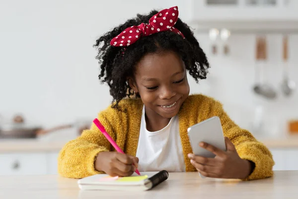 Online-Lektion. Schwarze Preteen Girl Studie mit Smartphone zu Hause — Stockfoto