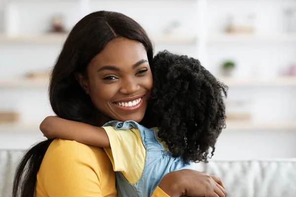 美丽的非洲裔美国妇女在家里抱着小女儿 — 图库照片