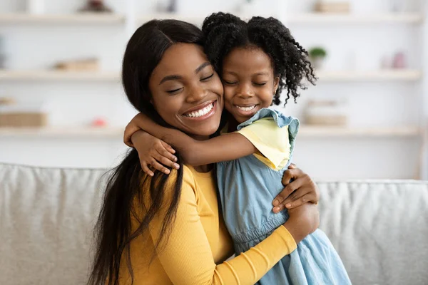 Μητέρα Κόρη αγάπη. Ευτυχισμένη μαύρη γυναίκα που αγκαλιάζεται με το παιδί της στο σπίτι — Φωτογραφία Αρχείου