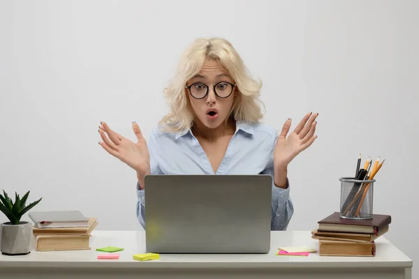 Känslomässig affärskvinna tittar på bärbar skärm i chock, kvinnlig kontorsarbetare sitter på arbetsplatsen, ljus bakgrund — Stockfoto