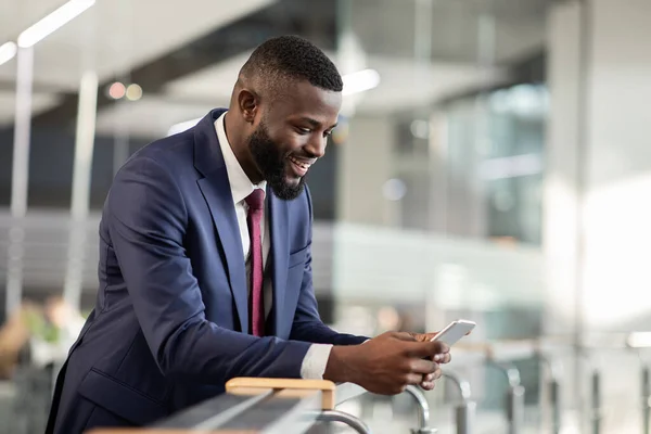 CEO hombre afroamericano utilizando la aplicación móvil de negocios en el teléfono inteligente — Foto de Stock