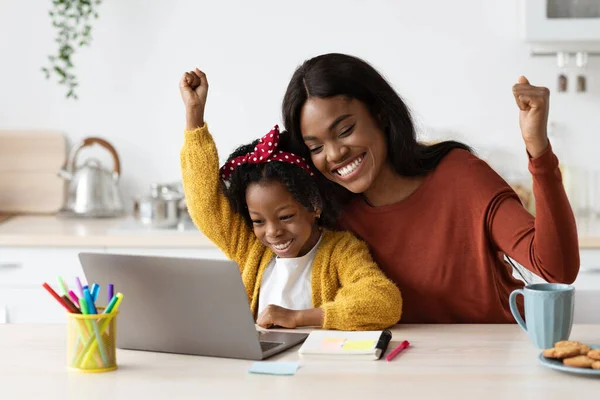Радостная чернокожая мать и маленькая дочка - в рейтинге Success с самым высоким рейтингом дома — стоковое фото