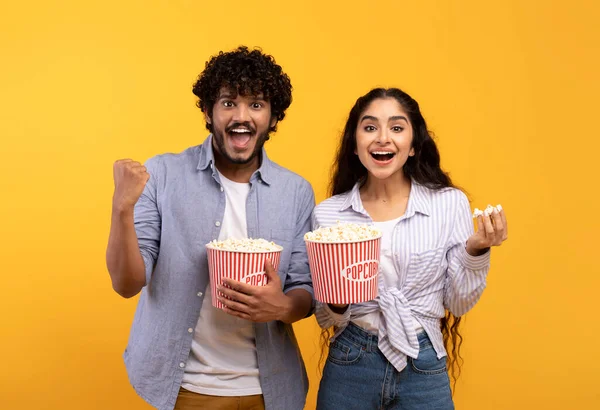 Homme et femme indiens excités mangeant du pop-corn, regardant un film ou un match de football, célébrant le succès de leur équipe — Photo